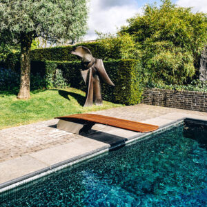 A sculpture of famous Belgian artist Reinhoud d'Haese is the perfect compagnion for this artisti c woden diving board.